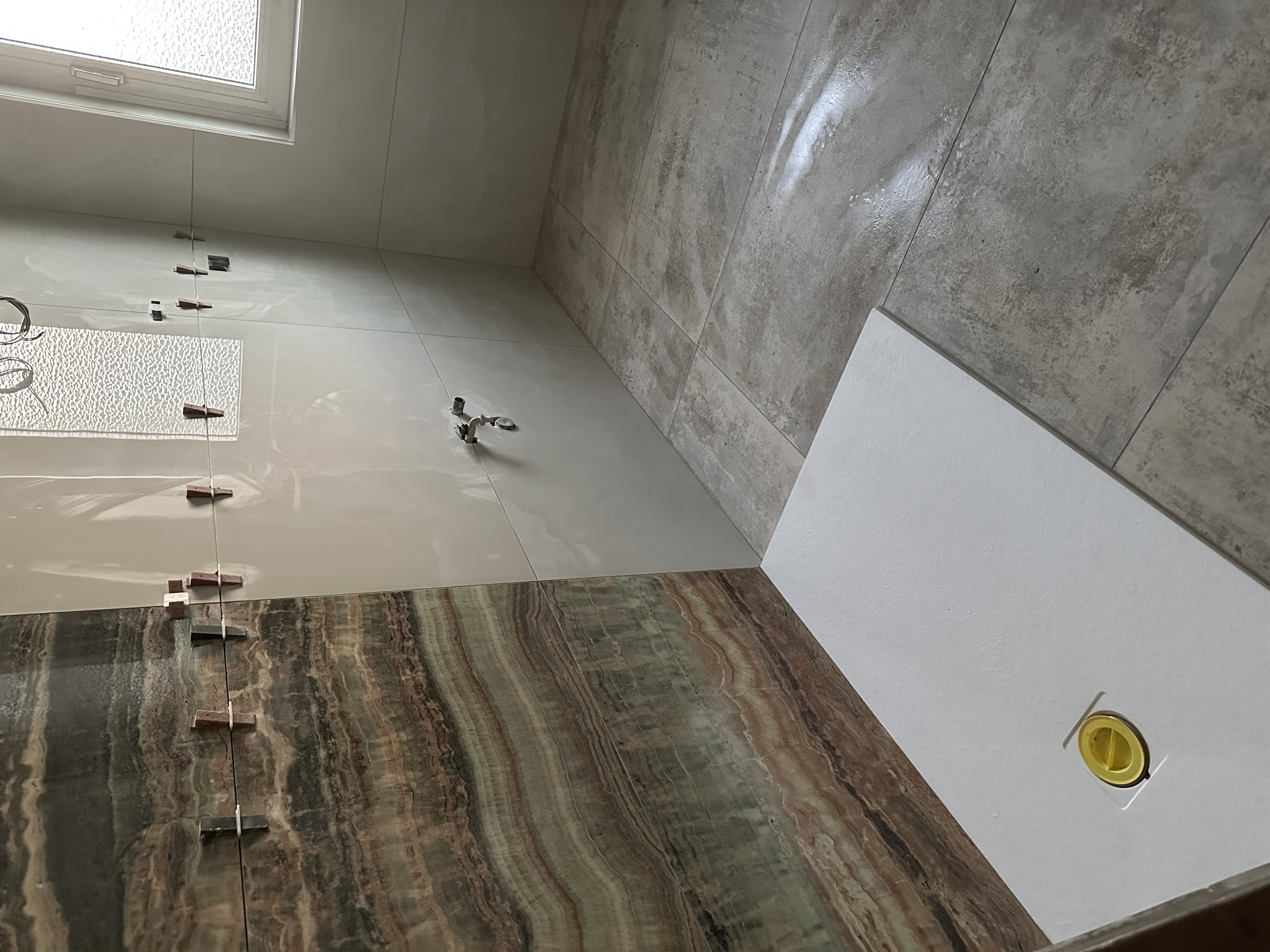 Posa di grandi lastre in marmo e pietra naturale per bagno di lusso — finiture premium in corso