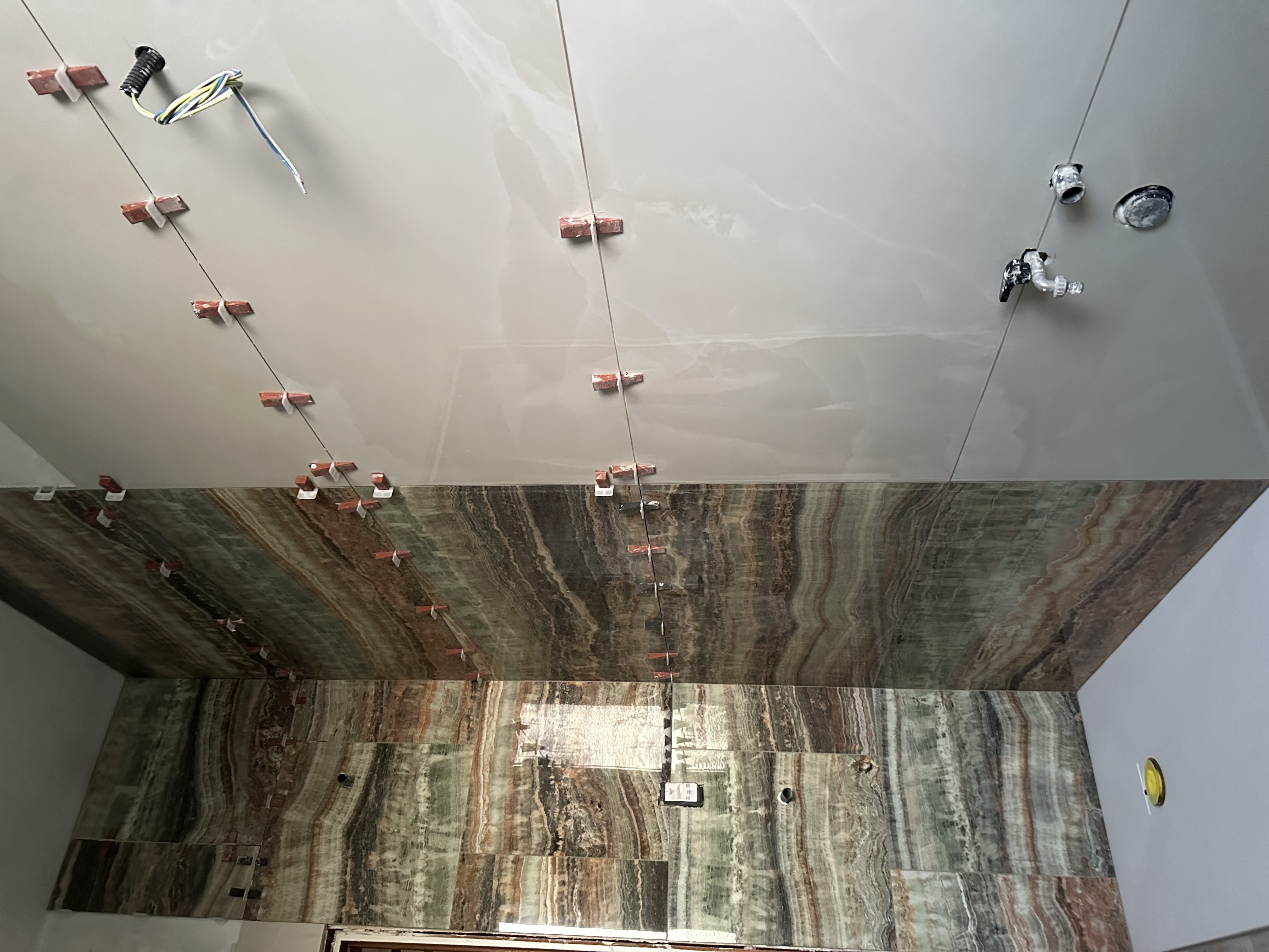 Posa di lastre in onice multicolor per rivestimento bagno di lusso — finiture su misura