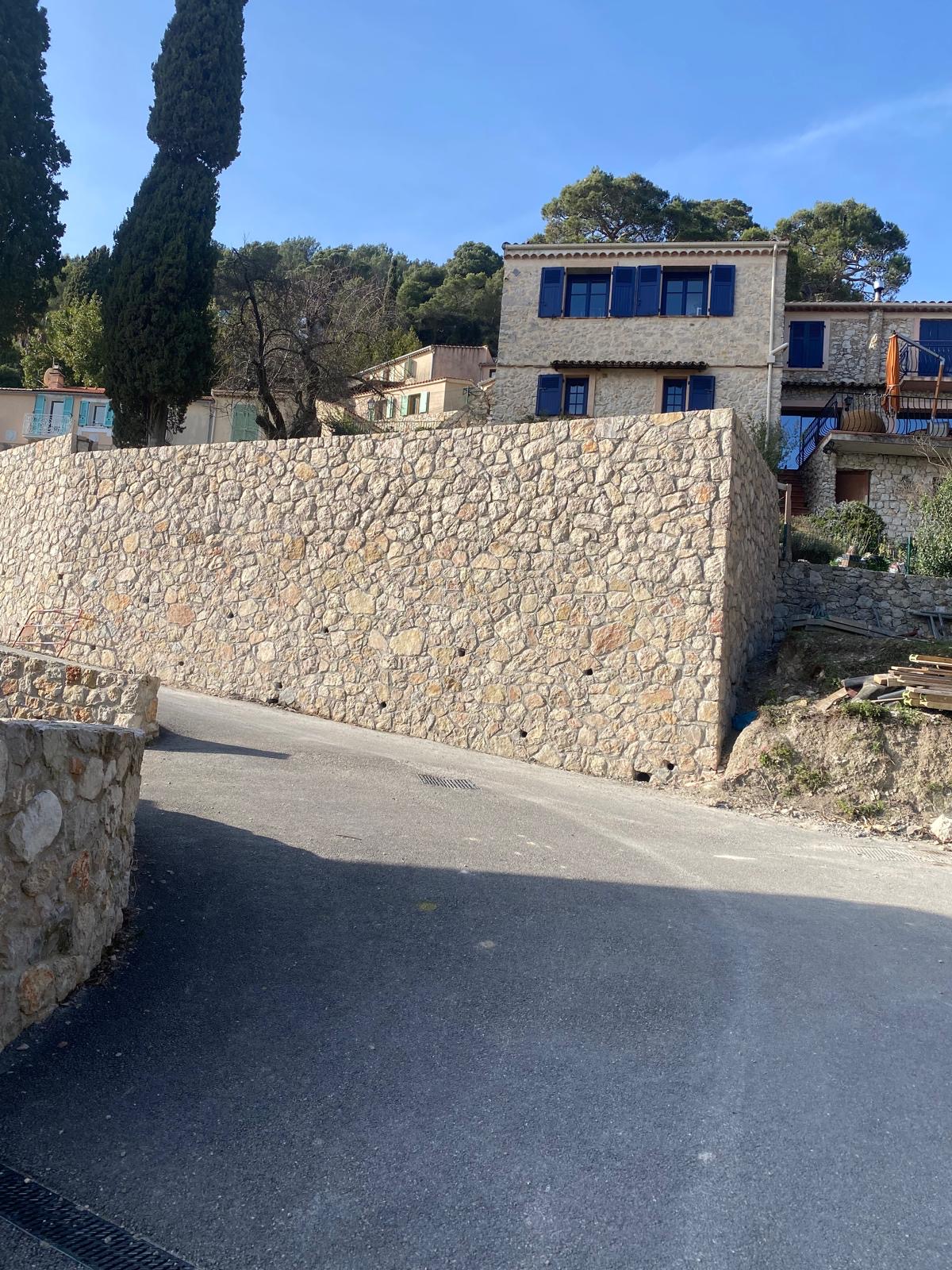 Muro a secco in pietra calcarea con villa e cipressi sullo sfondo — Liguria
